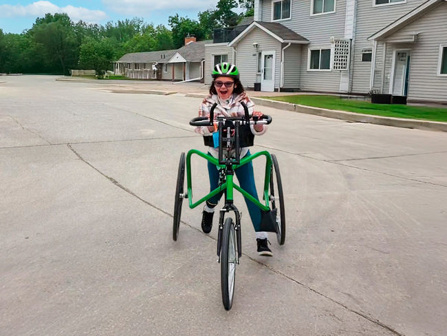 A girl moving on a green MANTIS Frame Runner in a parking lot